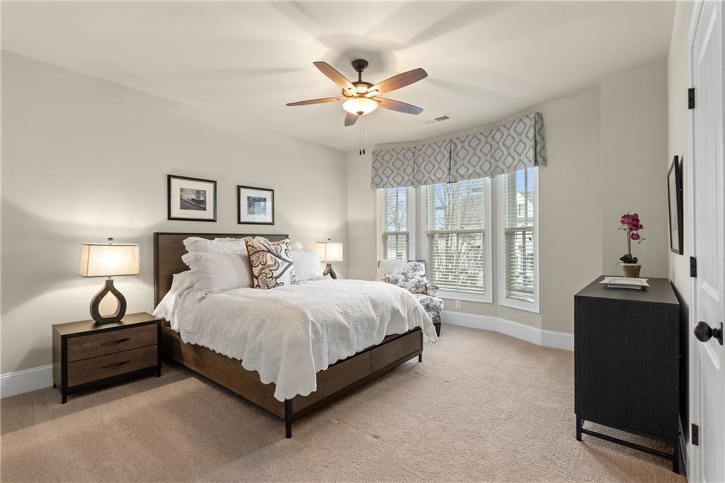 98 Academy Street Alpharetta, GA 30009 - Photo 31 of 56 a spacious bedroom with a bed and a chandelier
