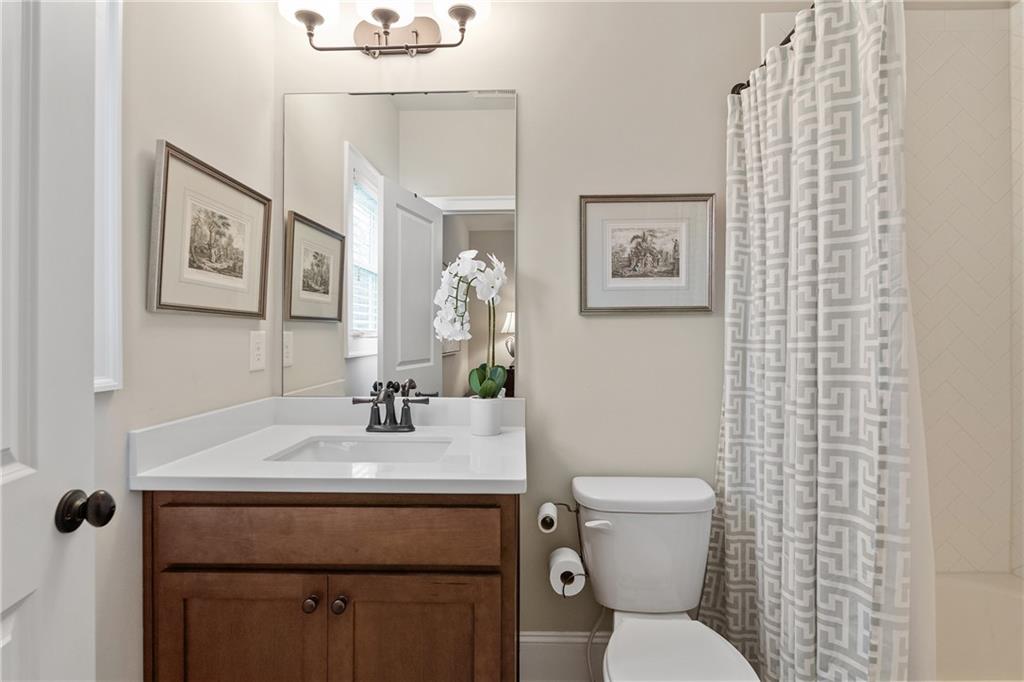 98 Academy Street Alpharetta, GA 30009 - Photo 34 of 56 a bathroom with a toilet a sink and mirror