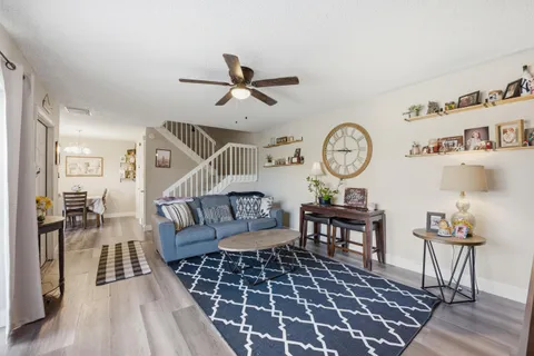 a living room with furniture a clock and a table