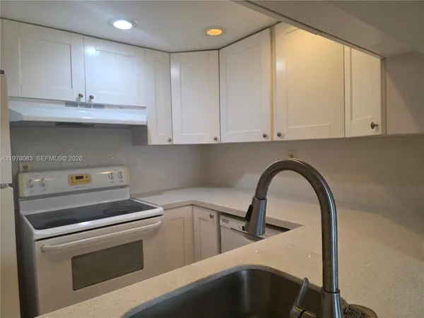 a kitchen with a white cabinets and white appliances