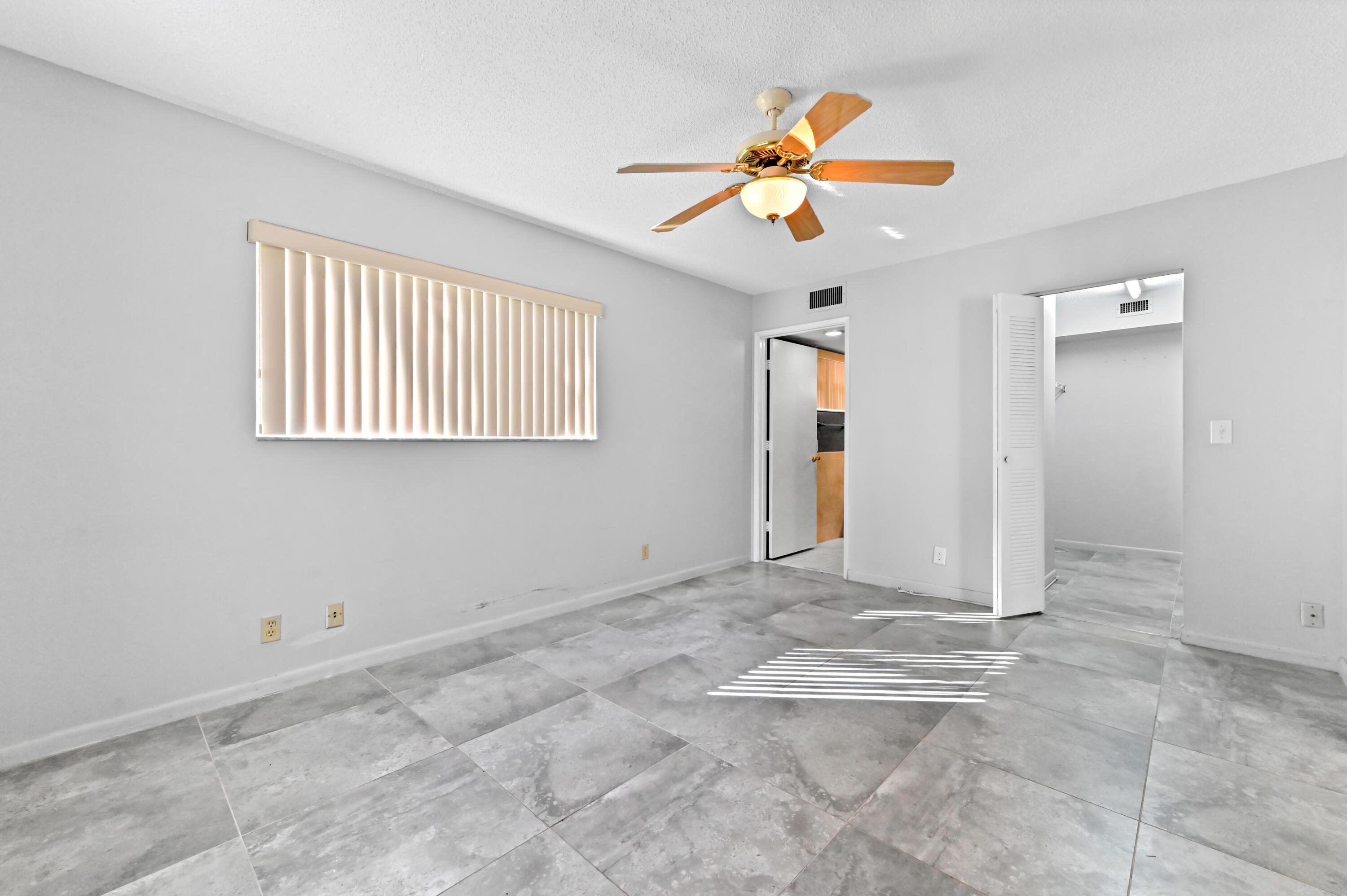 14895 Builtmore Way, Unit 107 Delray Beach, FL 33446 - Photo 20 of 40 a view of an empty room with window and chandelier fan