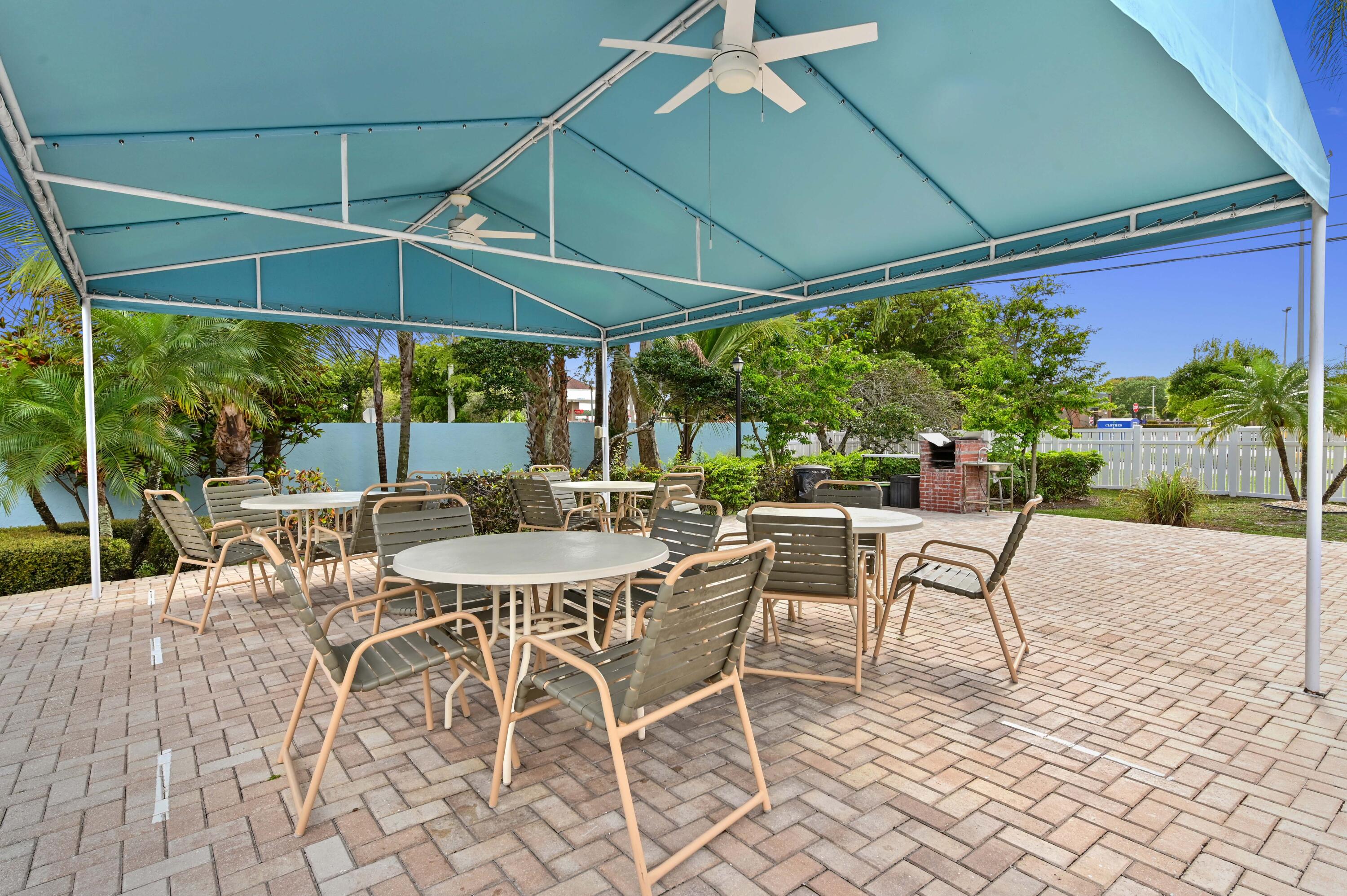 14895 Builtmore Way, Unit 107 Delray Beach, FL 33446 - Photo 27 of 40 a view of patio with table and chairs under an umbrella