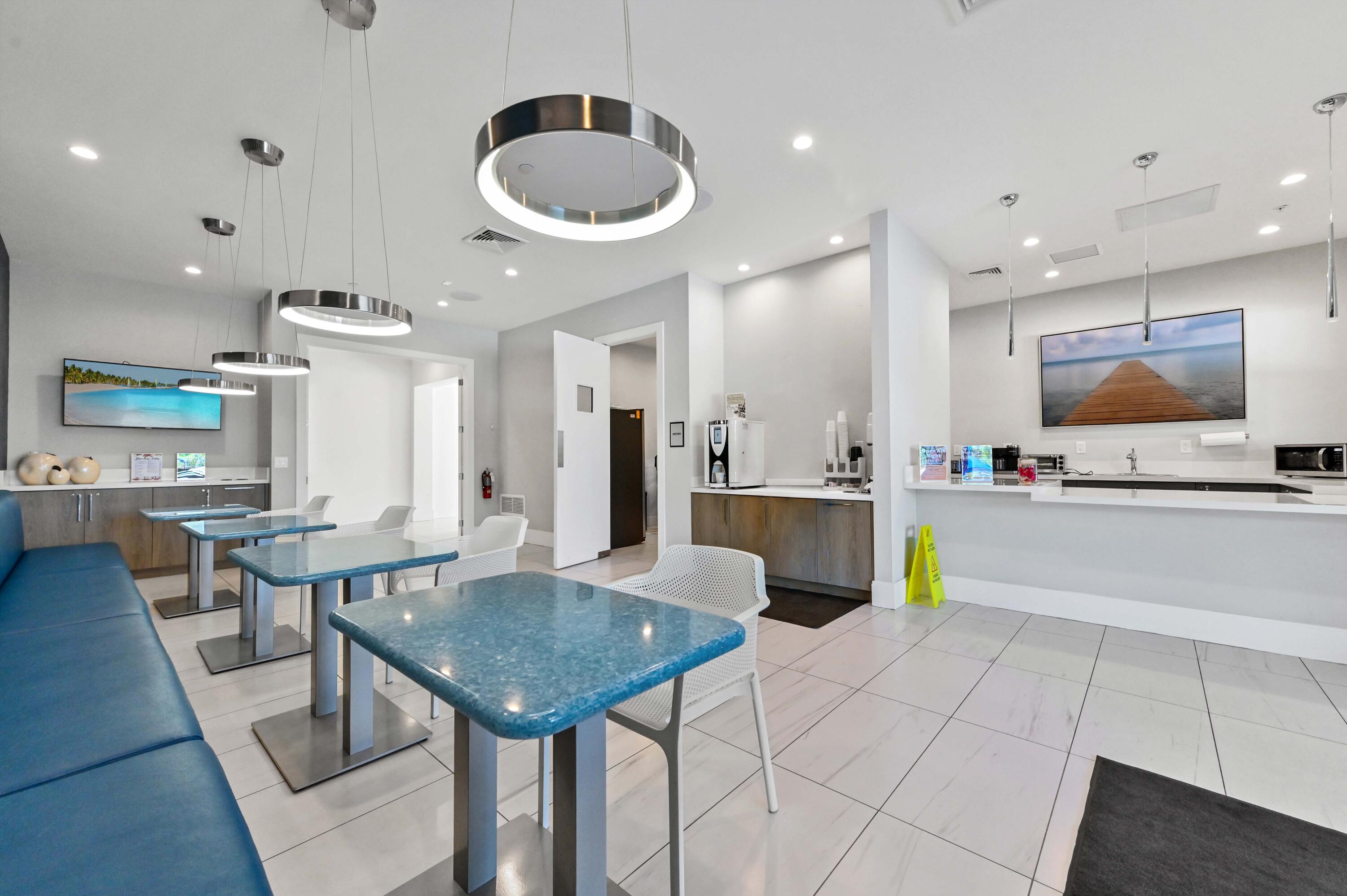 14895 Builtmore Way, Unit 107 Delray Beach, FL 33446 - Photo 34 of 40 a kitchen with stainless steel appliances granite countertop a sink dishwasher and a dining table with wooden floor