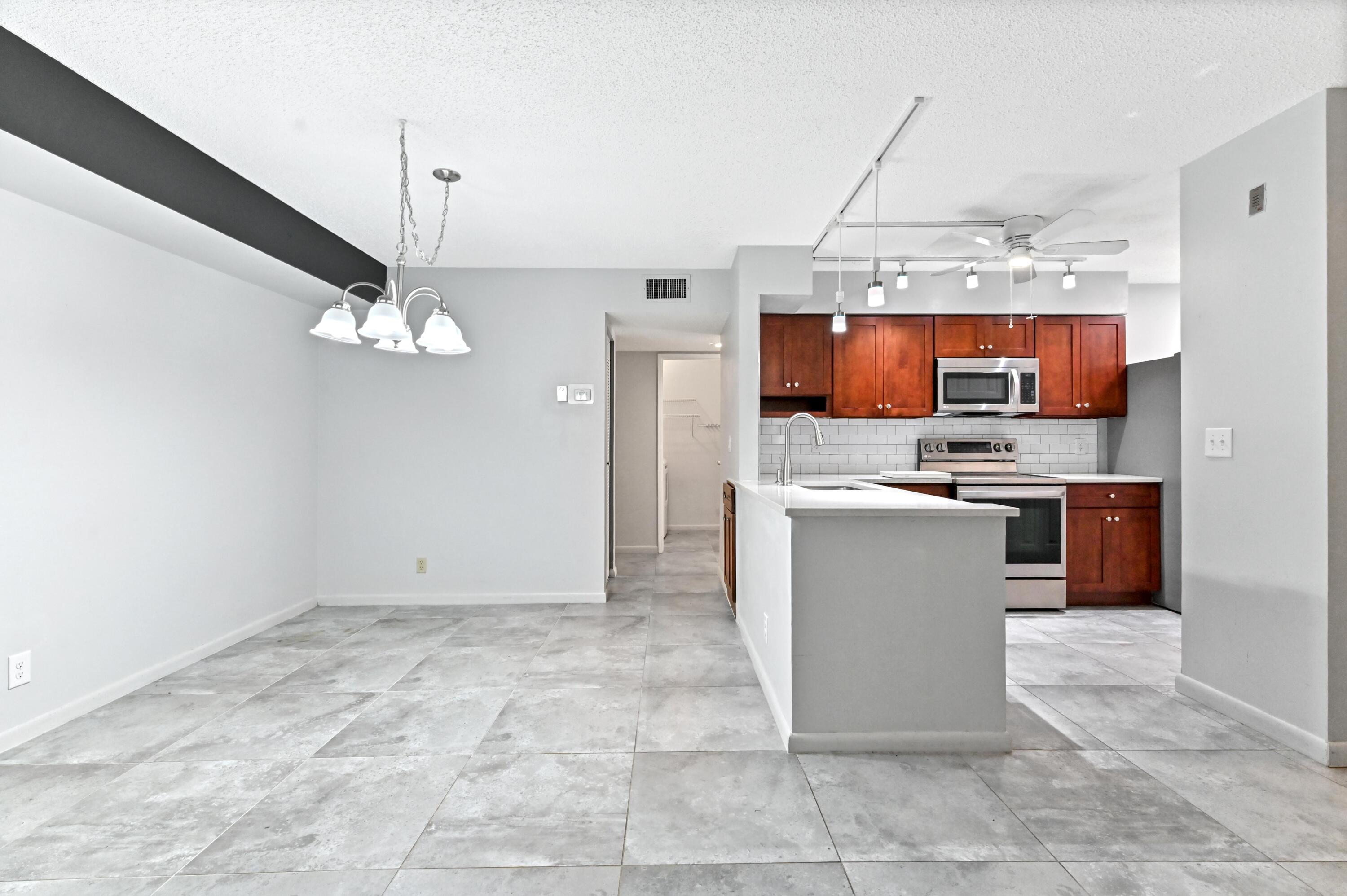 14895 Builtmore Way, Unit 107 Delray Beach, FL 33446 - Photo 4 of 40 a kitchen with stainless steel appliances granite countertop a refrigerator a stove a oven and a sink with granite countertops