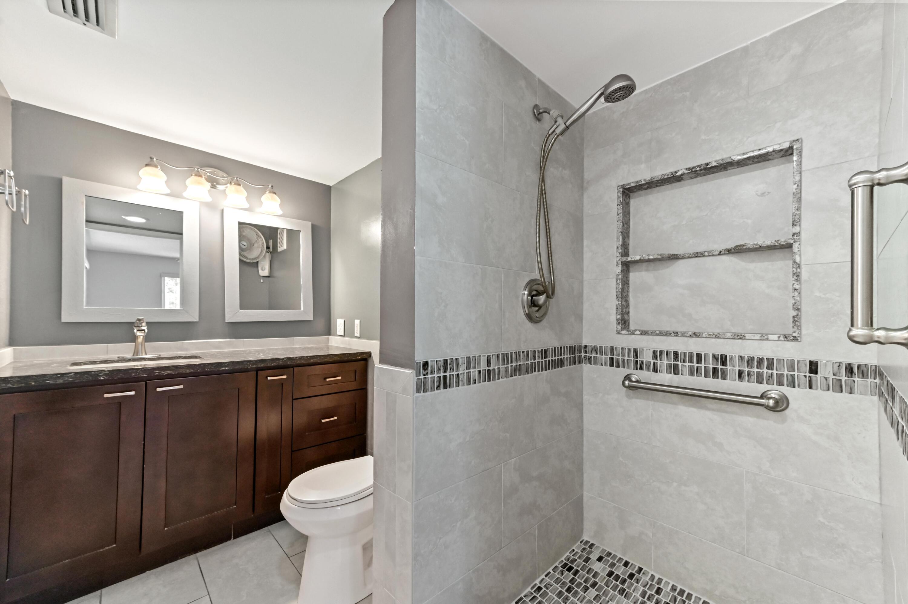 14895 Builtmore Way, Unit 107 Delray Beach, FL 33446 - Photo 8 of 40 a bathroom with a granite countertop sink toilet and shower