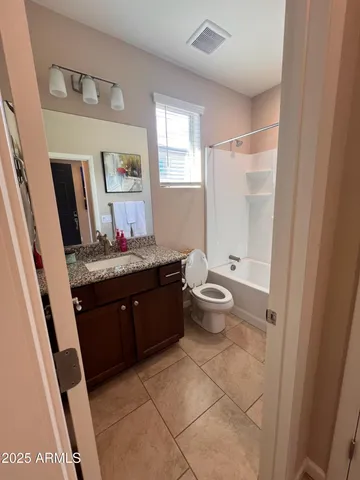 a room with a granite countertop sink a toilet and a mirror