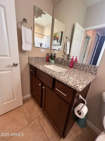 a bathroom with a granite countertop sink a toilet and mirror