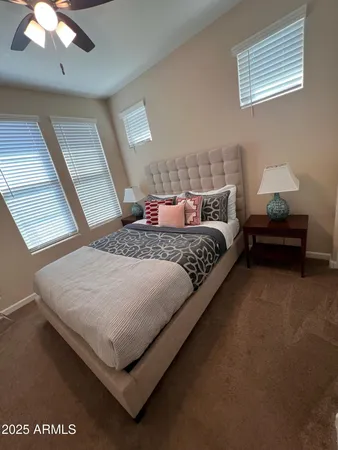 a bedroom with a bed lamp and a large window