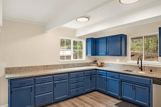 a kitchen with granite countertop wooden cabinets sink and window