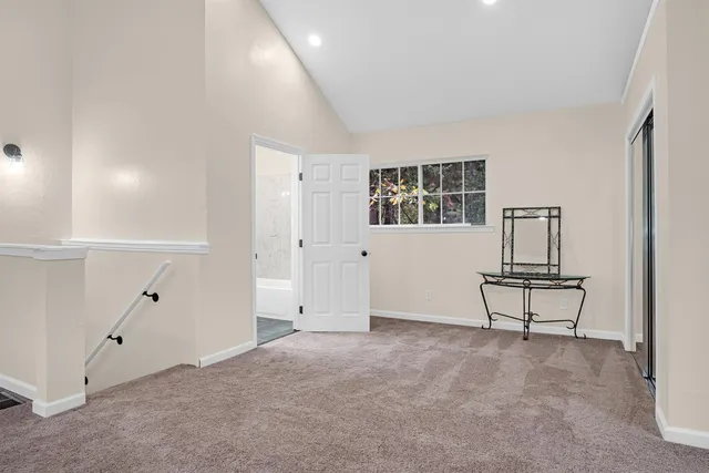 an empty room with windows and fireplace