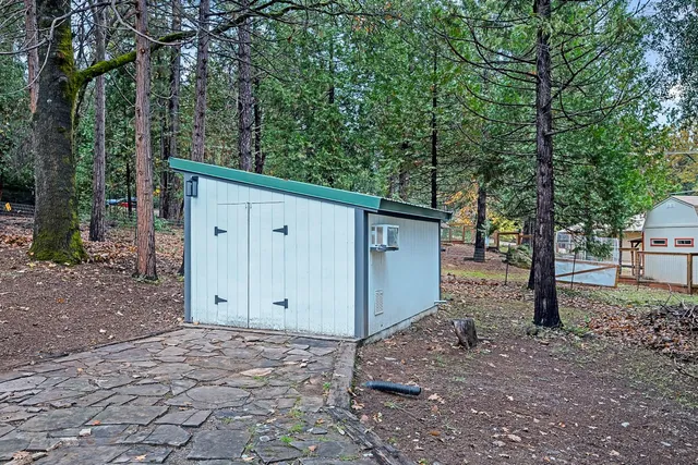 a view of a house with a backyard and trees