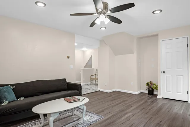 a living room with furniture and a wooden floor