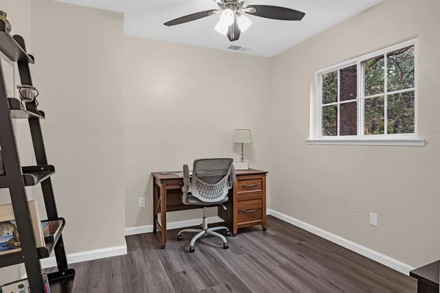 a view of a workspace with furniture and a window