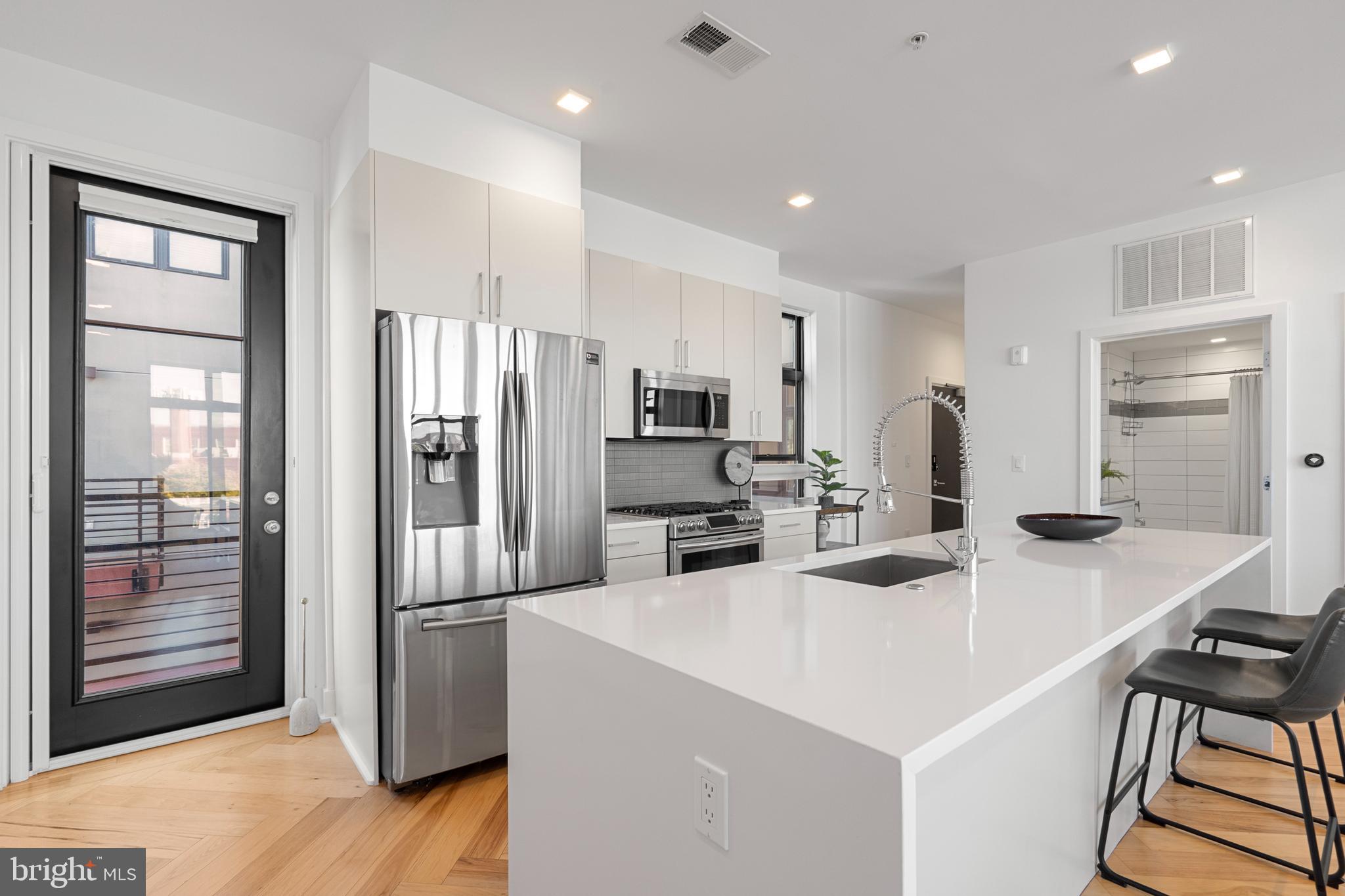 1345 K Street Southeast, Unit 401 Washington, DC 20003 - Photo 7 of 28 a kitchen with stainless steel appliances a refrigerator and a stove