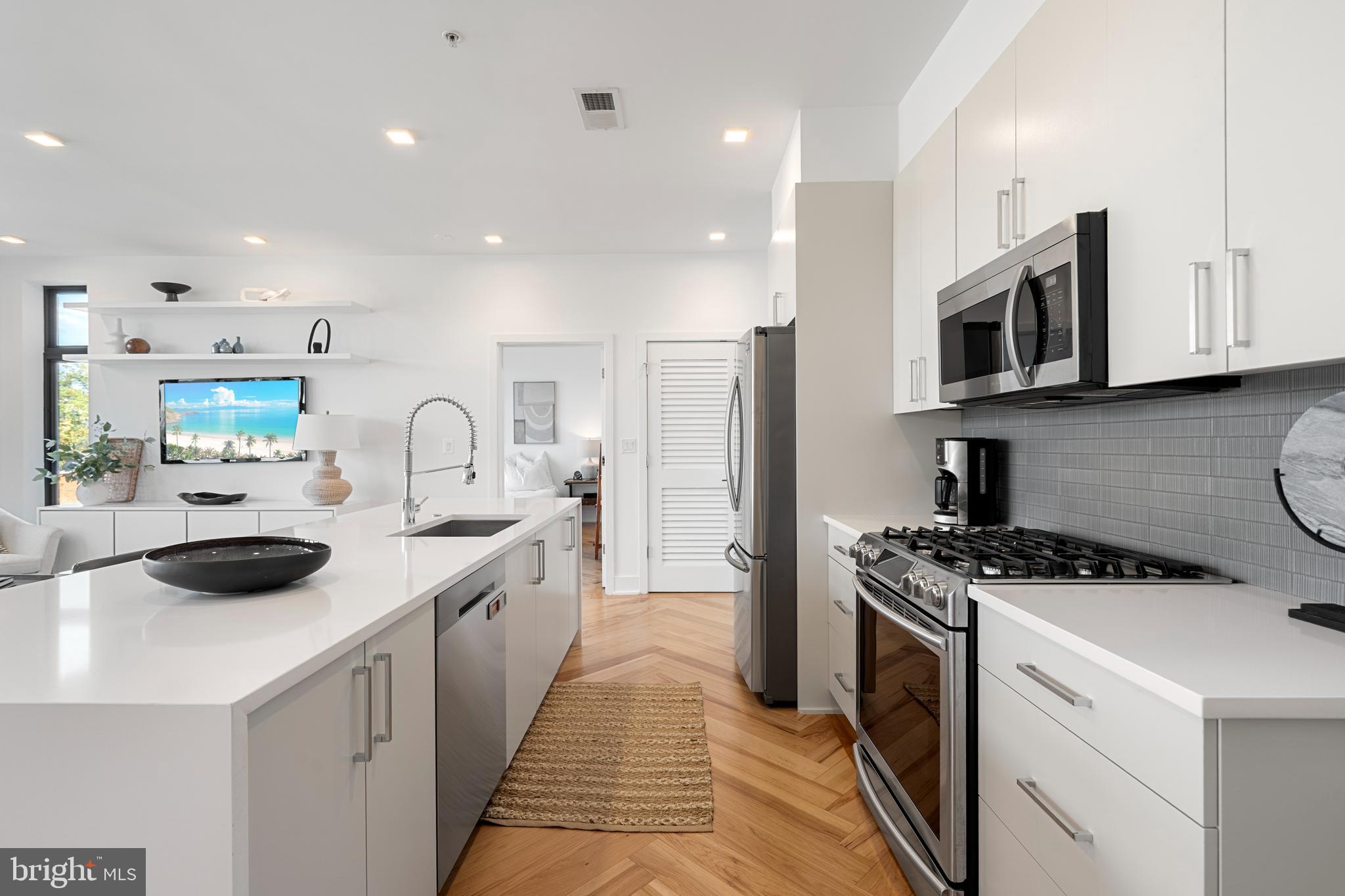 1345 K Street Southeast, Unit 401 Washington, DC 20003 - Photo 9 of 28 a kitchen with stainless steel appliances a stove sink microwave and cabinets