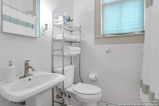 a bathroom with a sink a toilet and a mirror