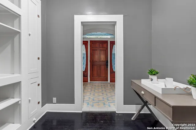 a view of a hallway with wooden floor and a cabinet