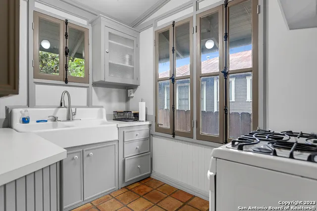 a kitchen with a stove a sink and a window