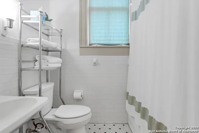 a white toilet sitting next to a bathroom sink