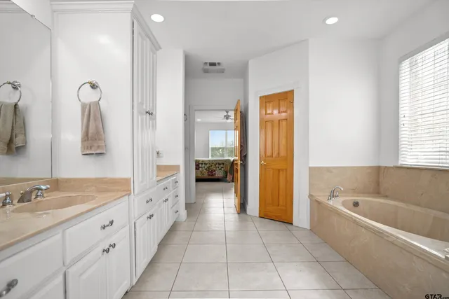 a spacious bathroom with a tub shower and sink
