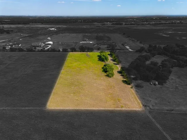 an aerial view of ocean and residential houses with outdoor space