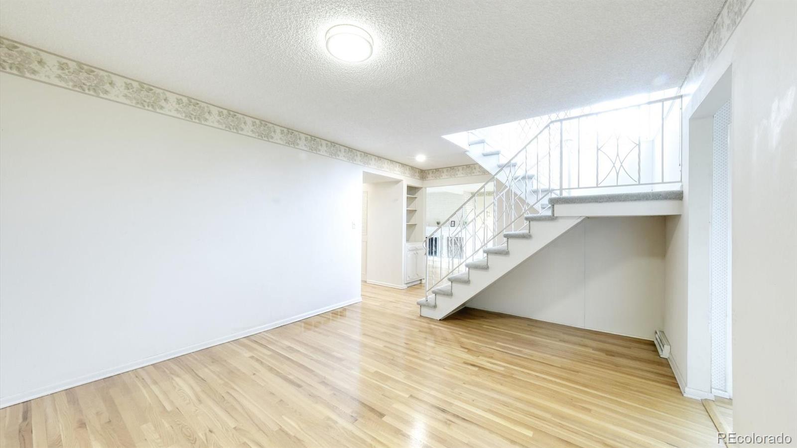 3292 South Oneida Way Denver, CO 80224 - Photo 11 of 44 a view of entryway and hall with wooden floor