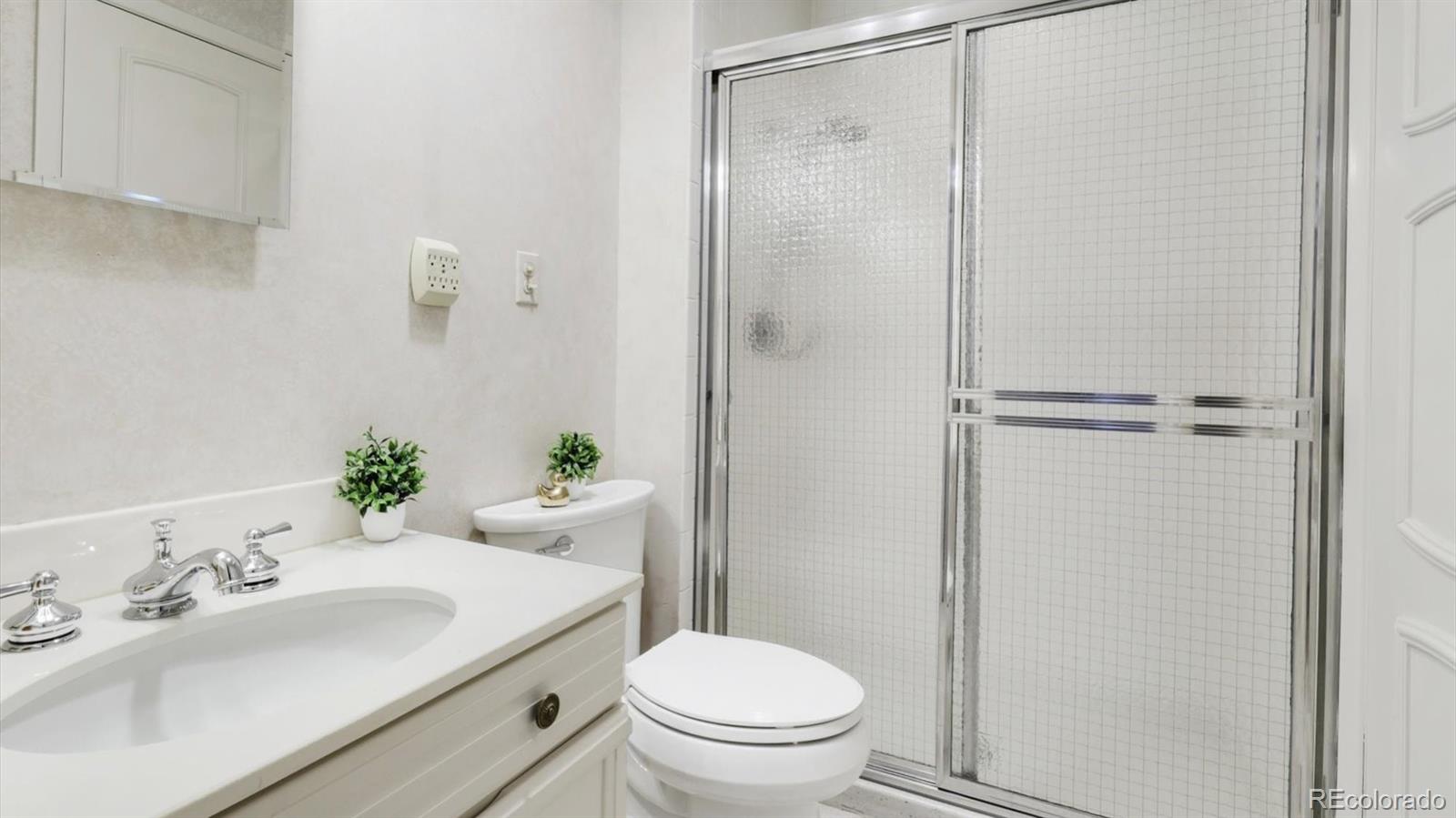 3292 South Oneida Way Denver, CO 80224 - Photo 16 of 44 a bathroom with a sink toilet and shower