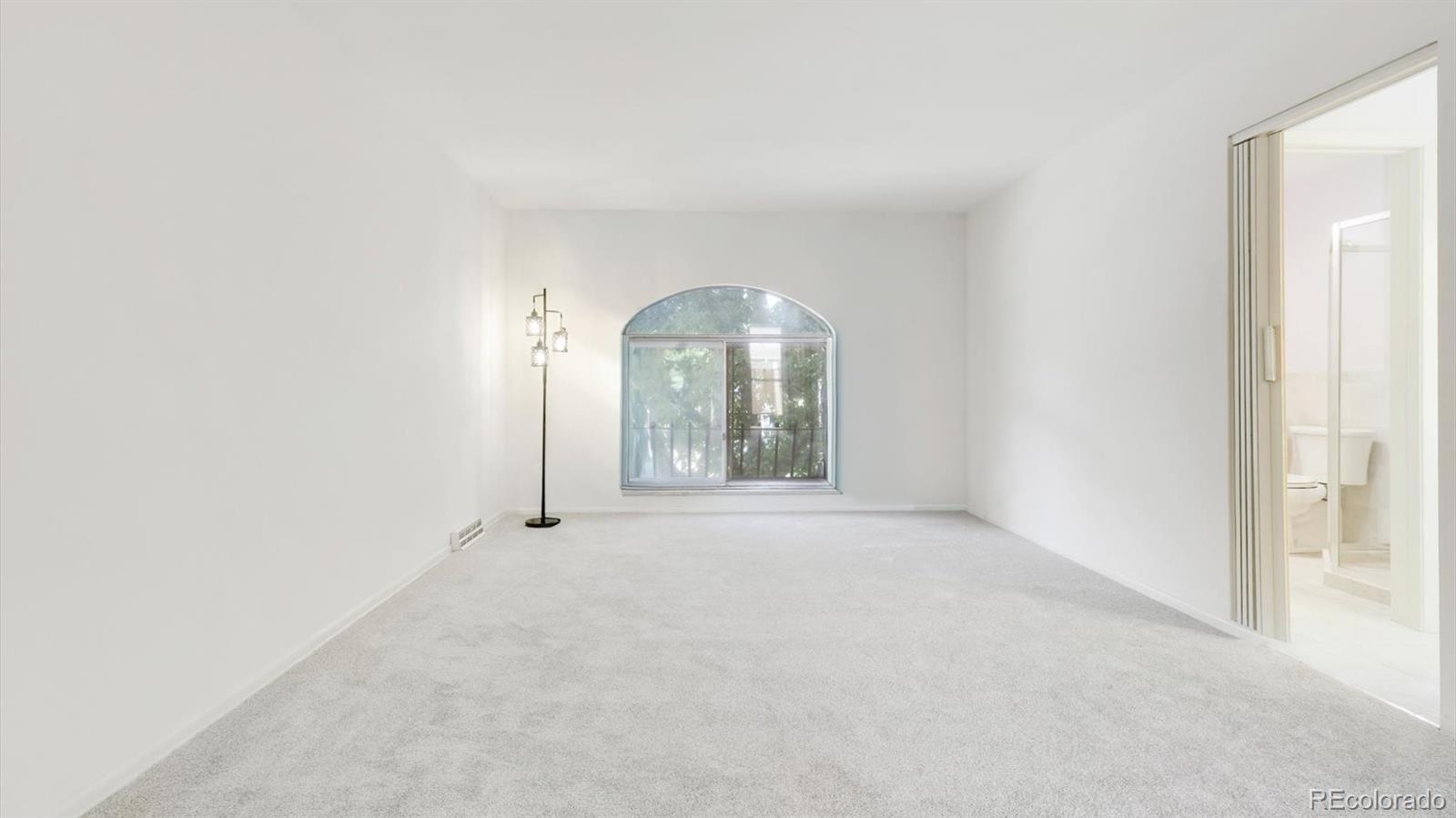 3292 South Oneida Way Denver, CO 80224 - Photo 22 of 44 an empty room with large windows and a fireplace