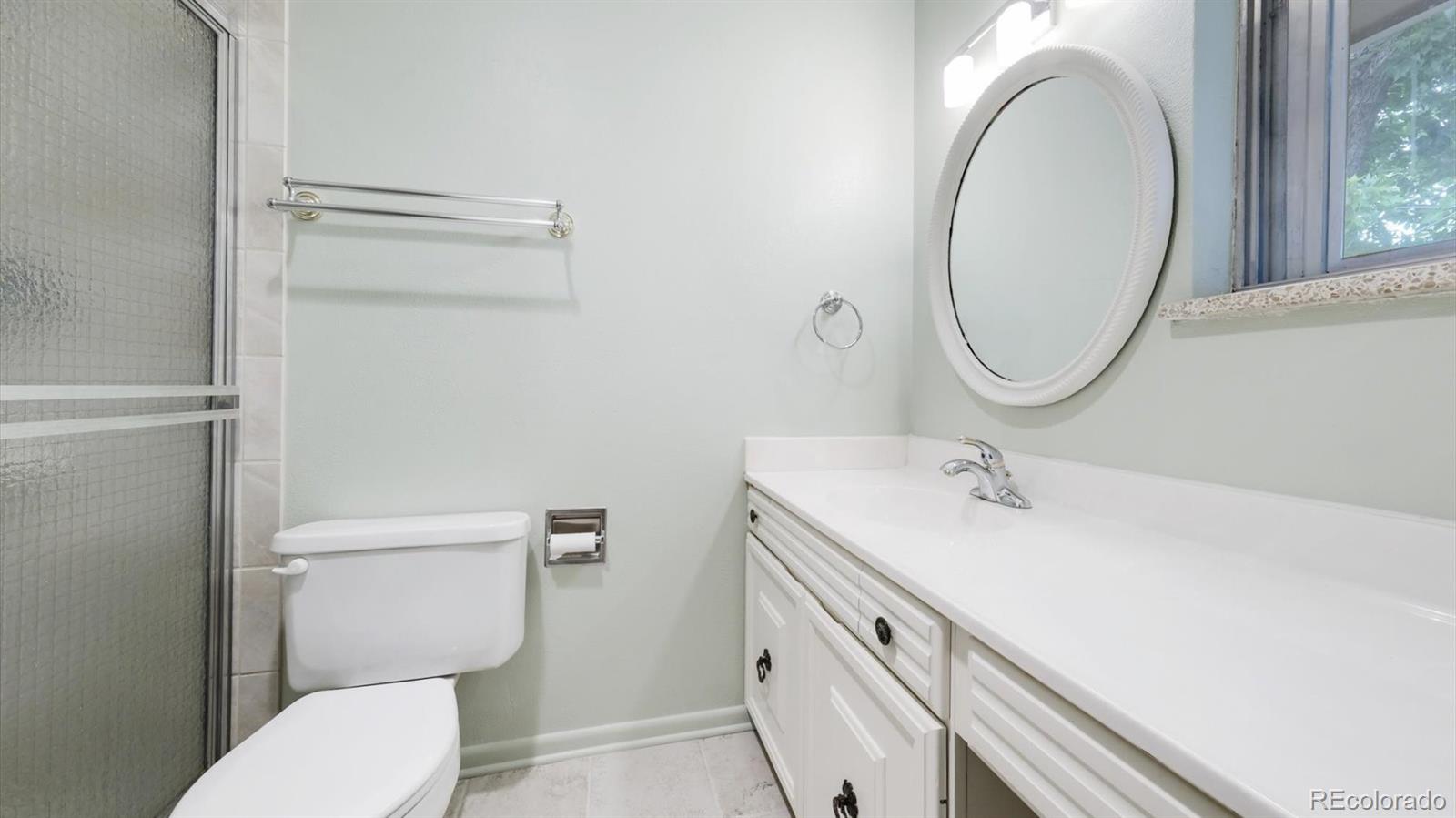 3292 South Oneida Way Denver, CO 80224 - Photo 33 of 44 a bathroom with a granite countertop toilet sink and mirror