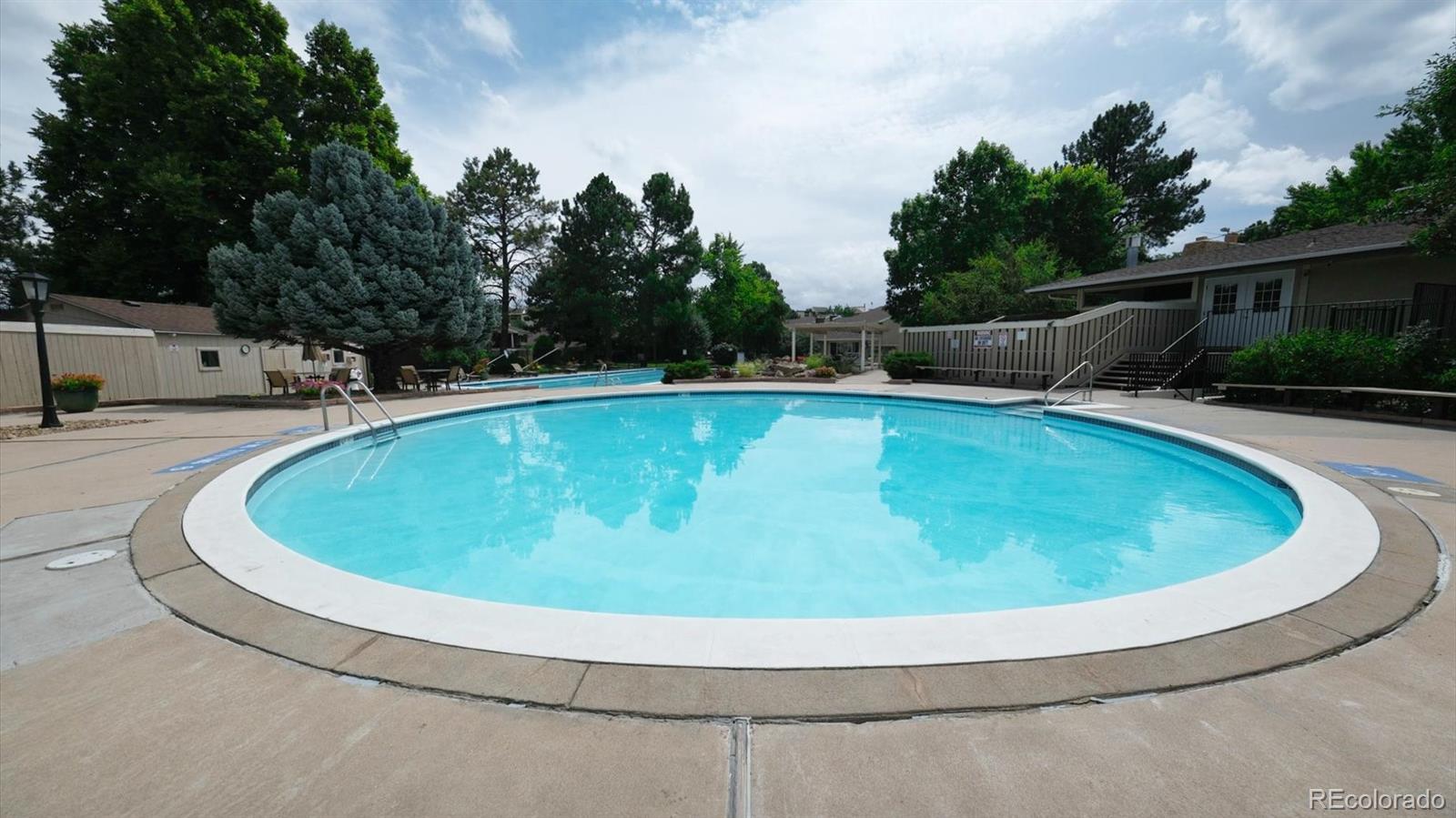 3292 South Oneida Way Denver, CO 80224 - Photo 34 of 44 a view of a swimming pool with a yard and trees in the background