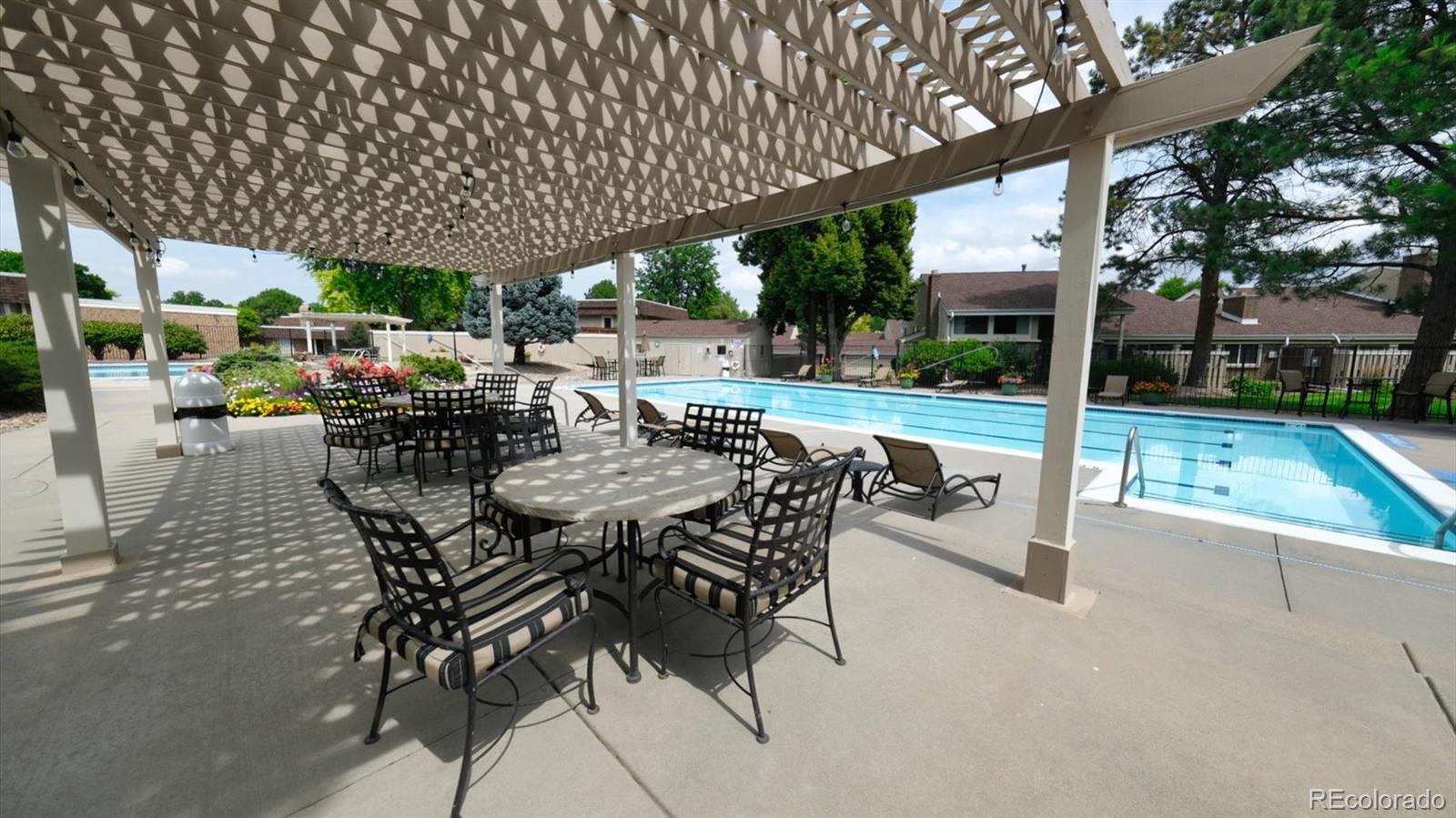 3292 South Oneida Way Denver, CO 80224 - Photo 37 of 44 a view of a patio with a table and chairs under an umbrella with a small yard