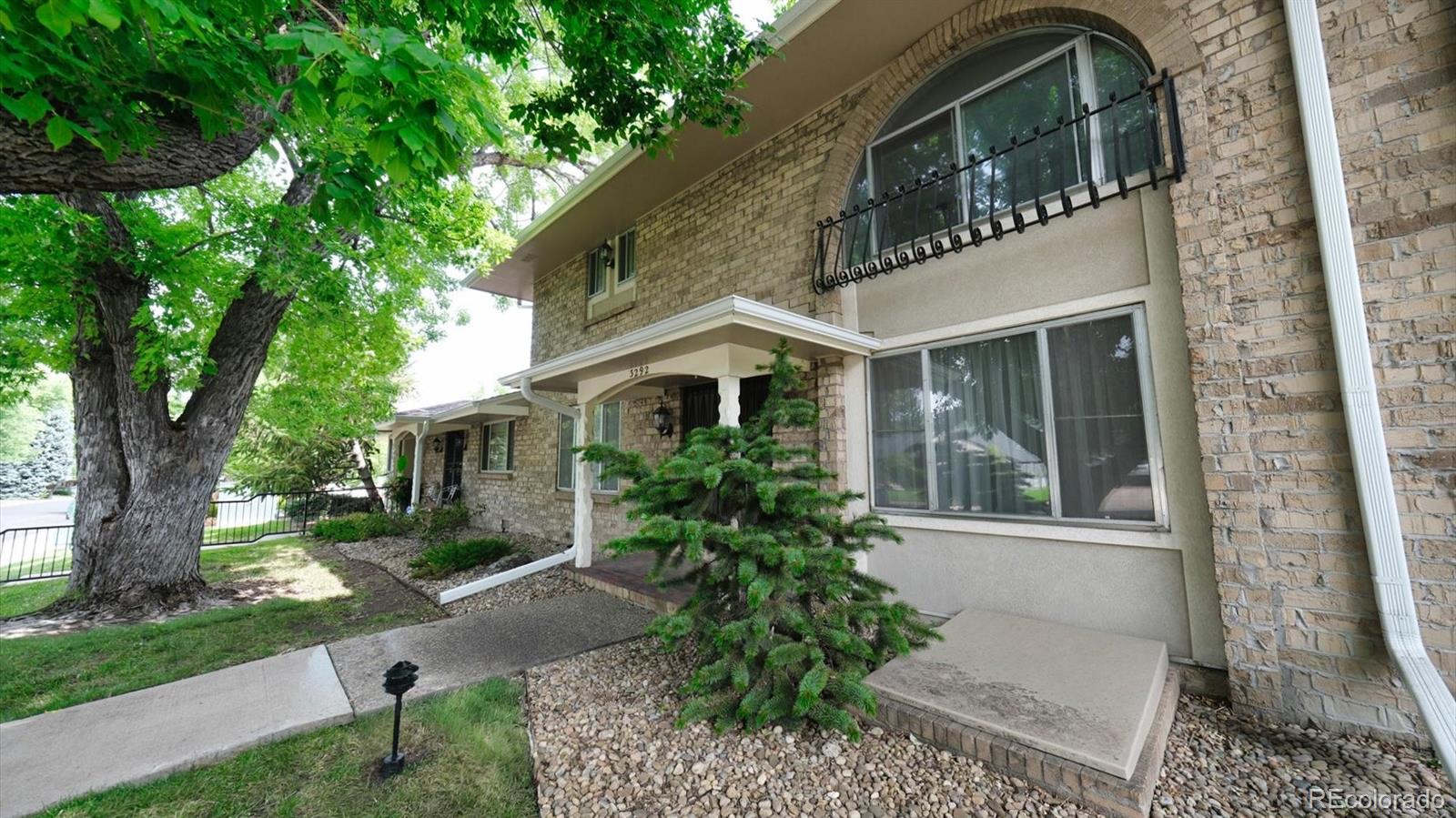 3292 South Oneida Way Denver, CO 80224 - Photo 4 of 44 a front view of a house with garden