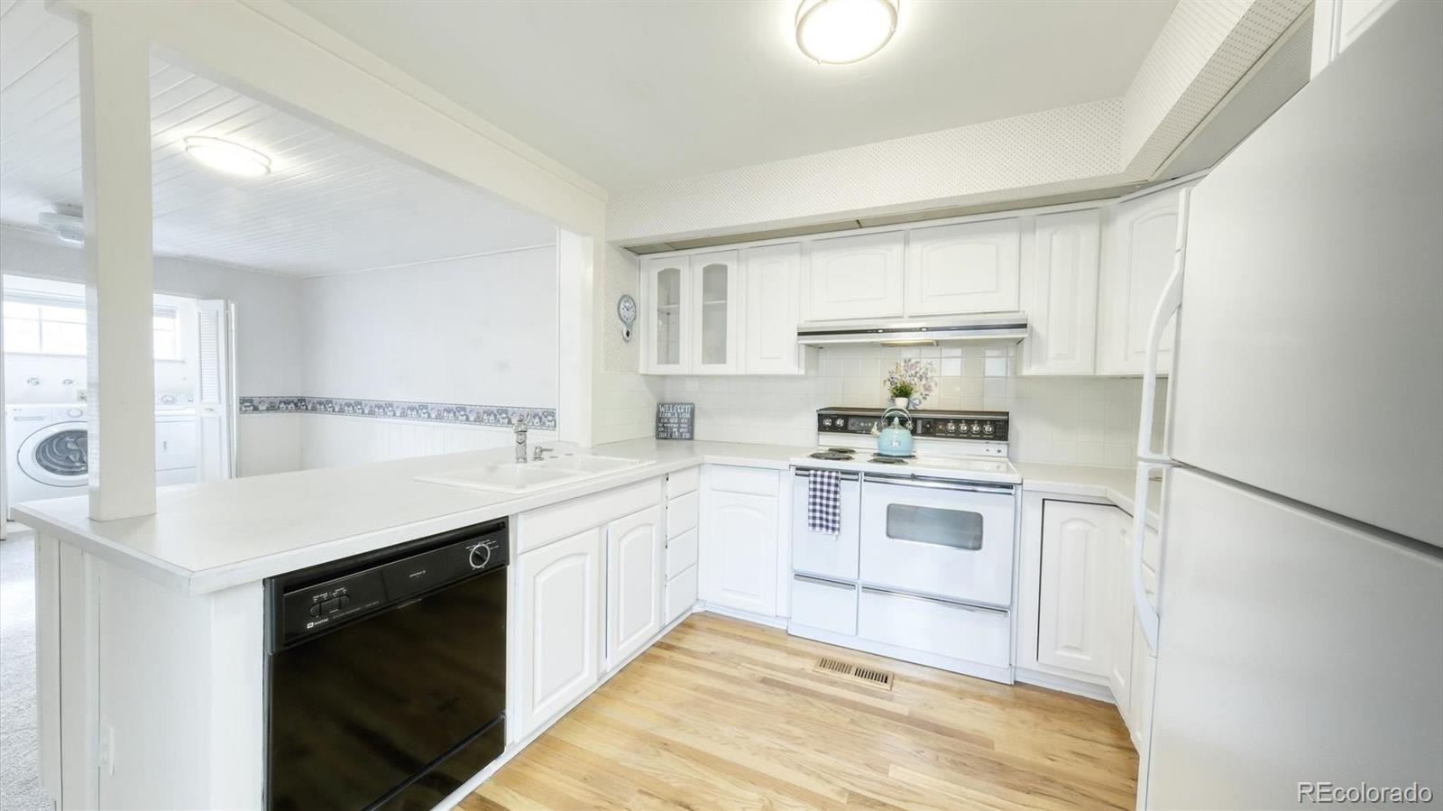 3292 South Oneida Way Denver, CO 80224 - Photo 8 of 44 a kitchen with a sink cabinets stainless steel appliances and a window