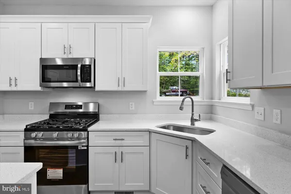a kitchen with cabinets appliances a sink and a window