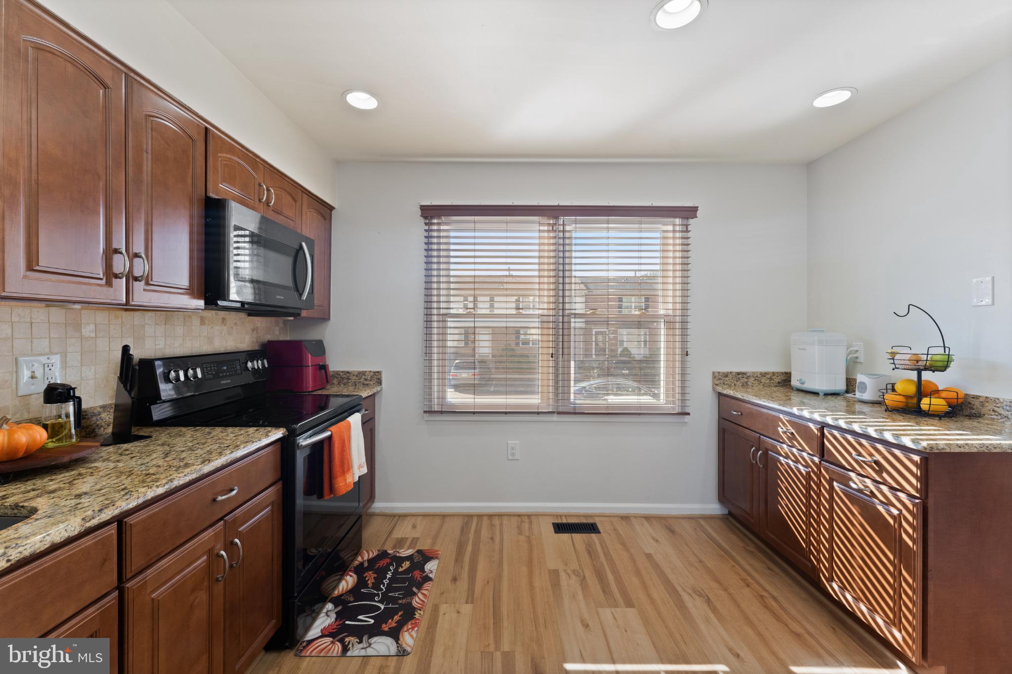 11 Briarstone Lane Gaithersburg, MD 20877 - Photo 11 of 31 a kitchen with granite countertop wooden cabinets and a stove top oven