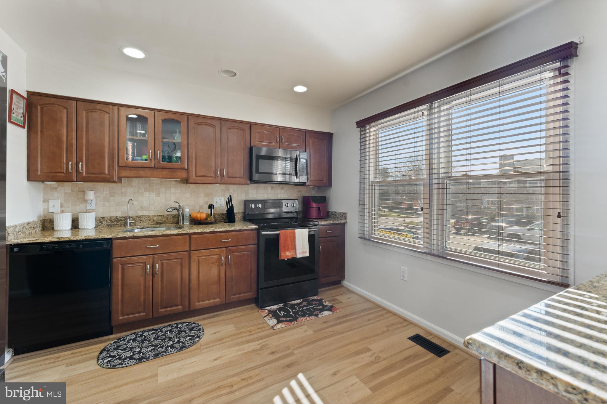 11 Briarstone Lane Gaithersburg, MD 20877 - Photo 13 of 31 a kitchen with granite countertop a stove a sink and a wooden cabinets