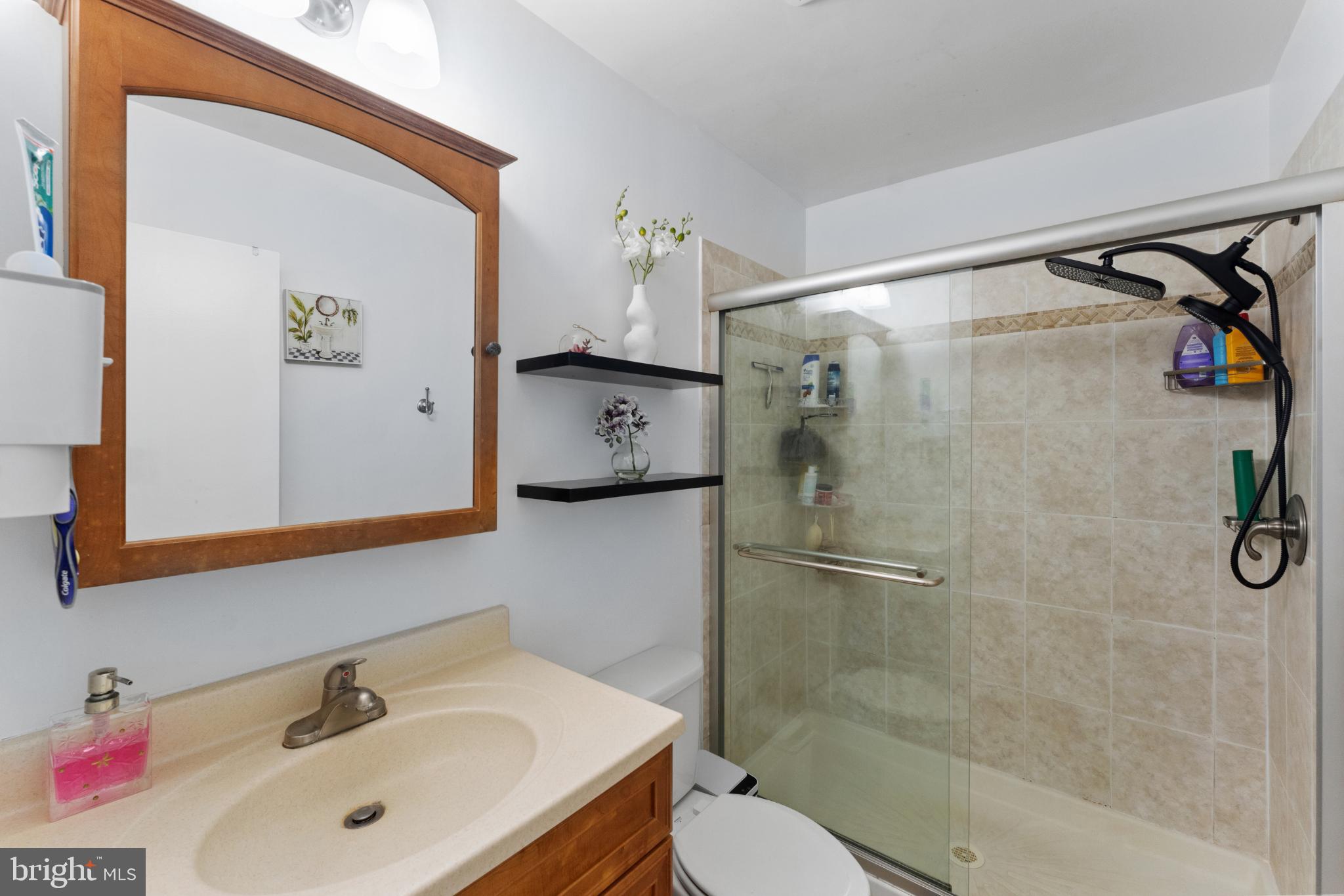 11 Briarstone Lane Gaithersburg, MD 20877 - Photo 25 of 31 a bathroom with a shower sink vanity and mirror