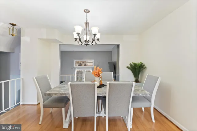 a dining room with furniture a chandelier and wooden floor