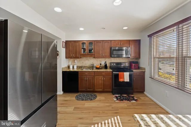 a kitchen with granite countertop a refrigerator and a stove top oven
