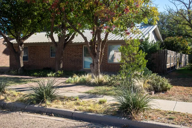 a view of a house with a tree in front of it