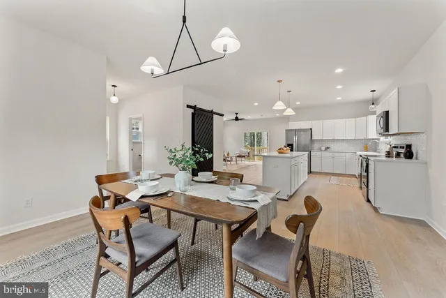 a dining room with furniture a chandelier and wooden floor