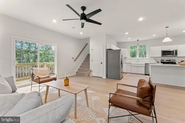 a living room with furniture and a view of kitchen