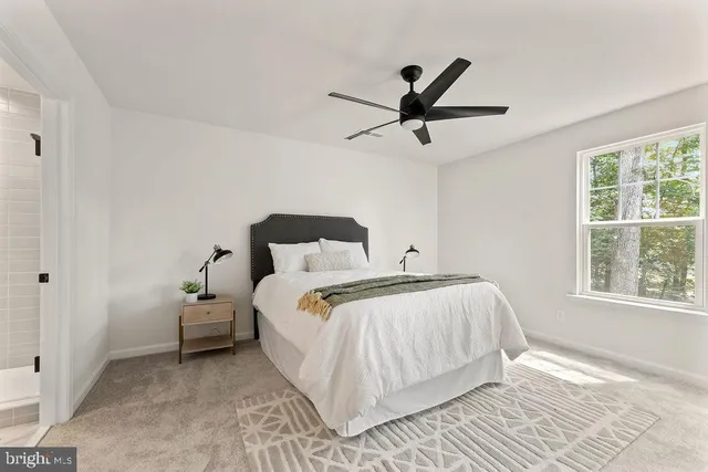 a spacious bedroom with a bed and a large window