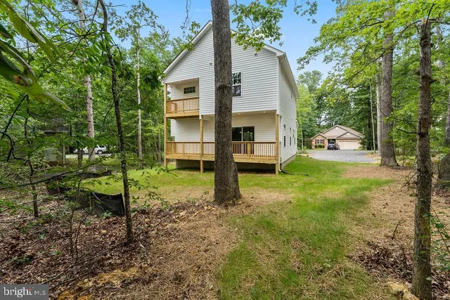 a view of a house with backyard and tree