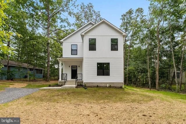 a view of a house with a yard and large tree