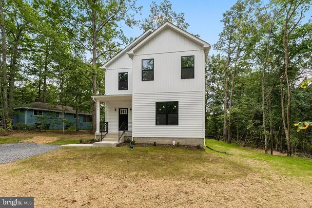 a view of a house with backyard and trees