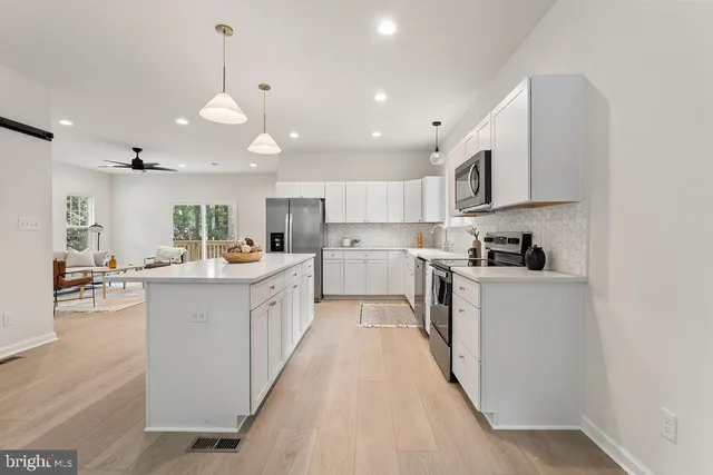 a large kitchen with stainless steel appliances lots of counter space and wooden floor