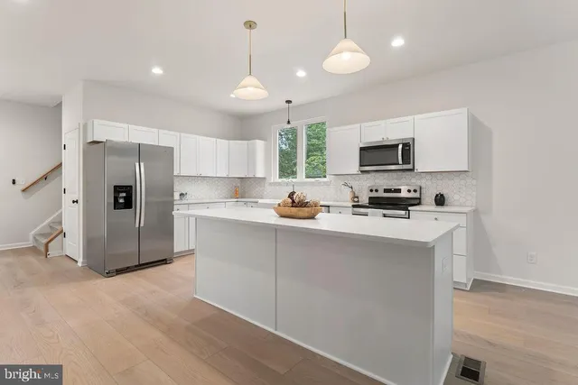 a kitchen with a sink a window and cabinets