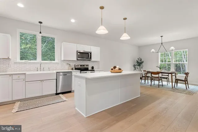 a kitchen with a refrigerator a sink and a stove top oven