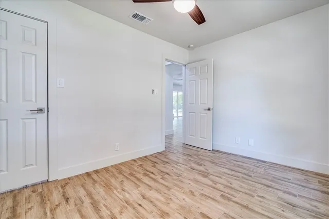 an empty room with window and wooden floor